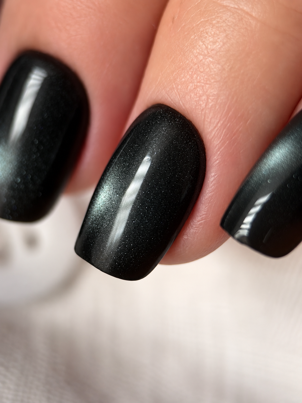Close-up of two Black Cat Eye press-on nails showing the shimmer band and glossy finish