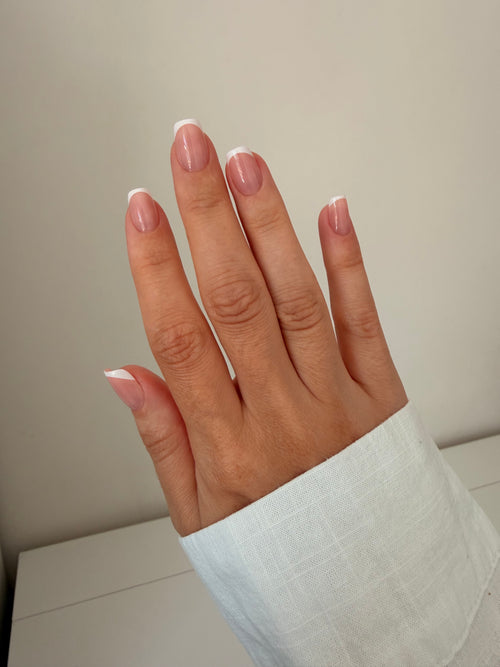 Classic French press-on nails on a hand, square short