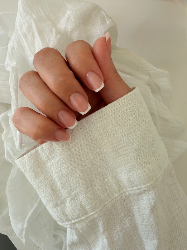 Classic French press-on nails on a hand, square short