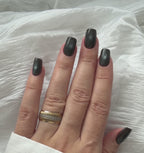 Black Cat Eye press-on nails moving in natural light, worn on one hand